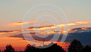 Sunset over a town and trees with a crane and shadows