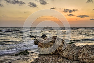 Sunset over tremble sea waves, with rocky seashore, israel