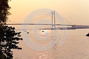 Sunset over Vidyasagar Setu a modern Cantilever Spar Cable-Stayed Bridge in a summer evening on the river Hooghly. Silhouette