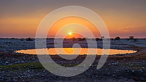 Sunset over the waterhole of Okaukuejo Camp in Etosha, Namibia