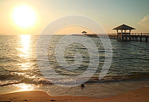 Sunset over the windy sea with a long wooden pier