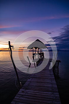 Sunset over wooden beach bar in sea and hut on pier in koh Mak island, Trat, Thailand