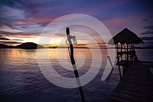 Sunset over wooden beach bar in sea and hut on pier in koh Mak island, Trat, Thailand