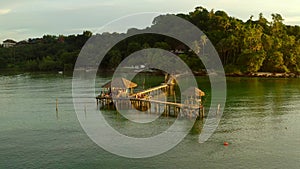 Sunset over wooden beach bar in sea and hut on pier in koh Mak island, Trat, Thailand