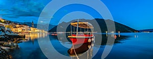 Sunset panorama of Kotor Bay and a docked boat in the town of Perast, Montenegro