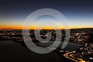 Sunset panorama over northern Lombardy lakes showing light pollution and Alps sihouette