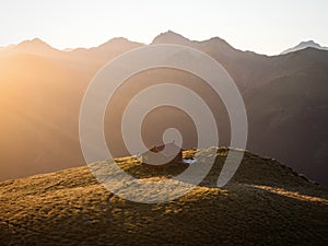 Sunset panorama of red idyllic remote lonely alpine mountain Brewster Hut above Haast valley Southern Alps New Zealand