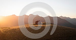 Sunset panorama of red idyllic remote lonely alpine mountain Brewster Hut above Haast valley Southern Alps New Zealand