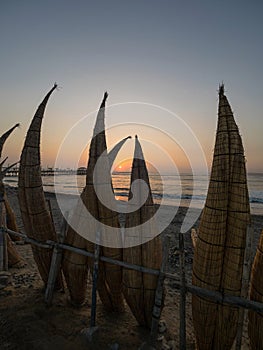 Sunset panorama traditional fishing boat Caballito de Totora reed sedge watercraft Huanchaco beach pacific Trujillo Peru