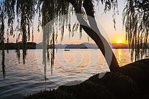 Sunset panoramic view of the West Lake in Hangzhou, China. Beautiful silhouettes in sunset colors