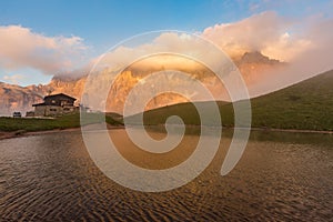 Sunset in Passo Rolle - Baita Segantini lake in Dolomite mountain range, Italy