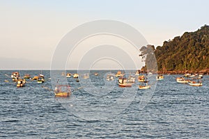 Sunset at PerequÃÂª beach with anchored fishermen`s boats, Guaruja, Brazil photo