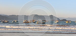 Sunset at PerequÃª beach with anchored fishermen`s boats, Guaruja, Brazil