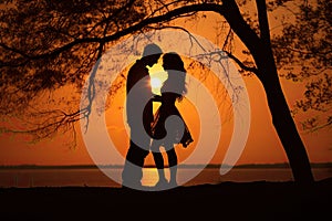 Sunset photo of silhouettes of a couple in love