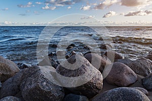 Sunset photo of the stones on the shoreline of the finnish bay in St. Petersburg. Rocks located on the beach. against the