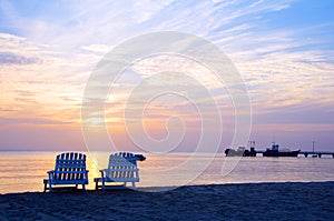 Sunset on Picnic Center beach lounge chairs and boats in distan