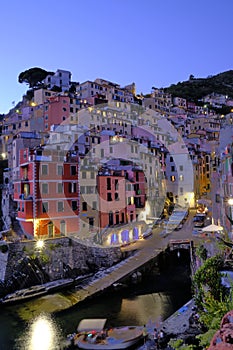 A SUNSET PICTURE OF THE COLORFUL HOUSES OF THE COASTLINE OF RIOMAGIORE