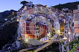 A SUNSET PICTURE OF THE COLORFUL HOUSES OF THE COASTLINE OF RIOMAGIORE