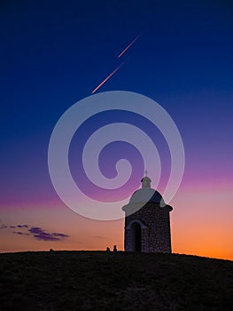 Sunset and Plane Trails over a small Chapel