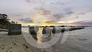 Sunset at Poole harbour with world war 2 tank traps in the foreground