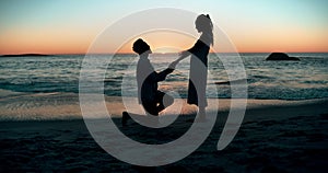 Sunset, proposal and couple at a beach with love, question or surprise romantic gesture in nature. Engagement, asking