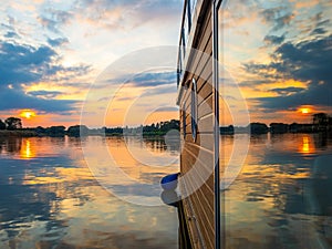 Sunset is reflecting in a window of a floating house in a warm summer evening