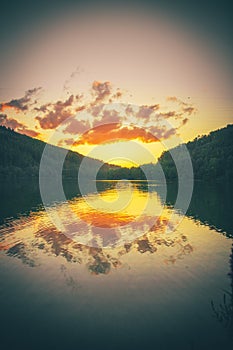 Sunset reflection, A lake in the forest in a natural landscape evolving with the sunset, Marbachstausee, Hesse, Germany photo