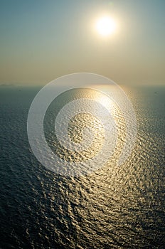 High view of sunset and reflection over the ocean on a smoggy day photo