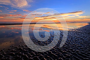 Sunset reflection with wavy sand patterns