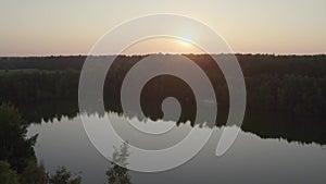 Sunset Revelation: Aerial Ascend Over Tree to Forest Lake View