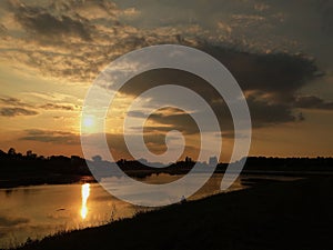 Sunset on the river with cloudy sky and reflection