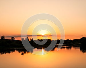 Sunset on the river. The sun forms a reflection on the water.