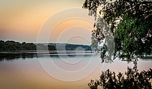 Sunset on the river with tree reflection