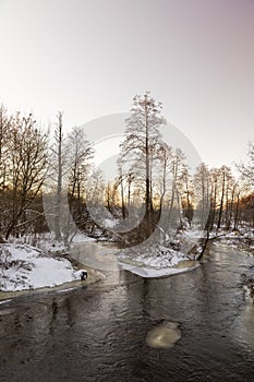 sunset on a river whose banks are covered with ice photo