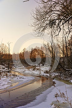 sunset on a river whose banks are covered with ice photo