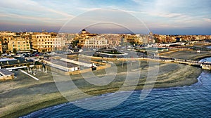 Sunset Rome aerial view in Ostia Lido beach over blue sea with city skyline and view of Ravennati square and pedestrian pier a