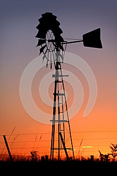 Sunset in a rural outback Australian farm silhouetting a wind pump