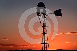 Sunset in a rural outback Australian farm silhouetting a wind pump