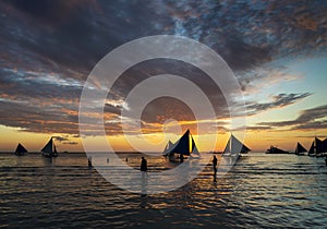 Sunset with sailing boats and tourists in boracay island philippines