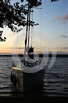 Sunset sailing yacht sailboat moored on a dead lake