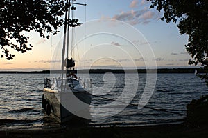 Sunset sailing yacht sailboat moored on a dead lake