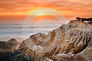 Sunset with sand cliffs on the coast of Portugal