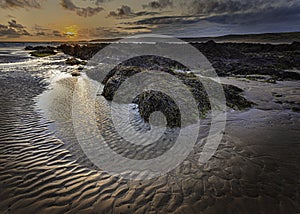 Sunset scene on beautiful rocky beach in Freshwater West on Pembrokeshire coast,South Wales, UK