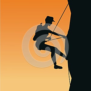 Sunset scene of black silhouette man mountain descent with harness rock climbing