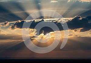Sunset scene with dramatic crepuscular rays streaming through clouds