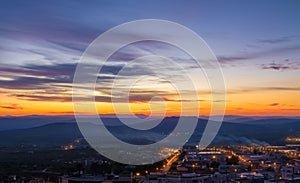 Sunset scene with mountains in background and city Matera in foreground, industrial view