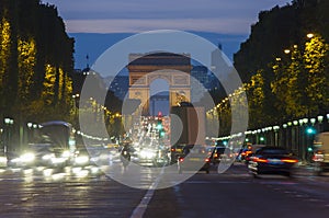 Sunset scene in Paris city. Long exposure photo of street traffic near Arc de Triomphe