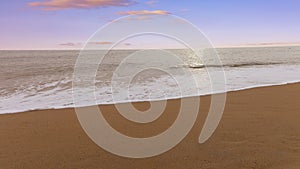 Sunset scene with wave water in the Tropical summer beach with sandy beach