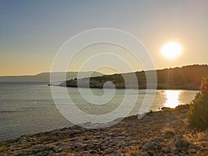 Sunset on sea and green hills surrounding