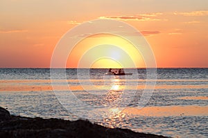 Sunset at sea with moving kayak.